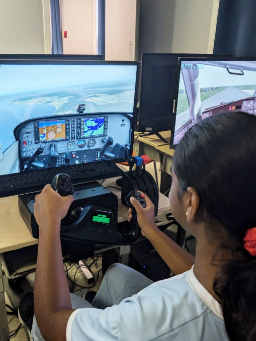 Élève du secondaire et simulateur de vol dans le cadre du programme Simulateur de vol et découverte de l'aviation d'Aviation Connection.