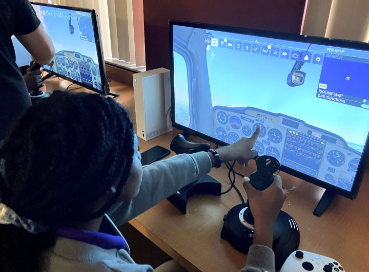 Élève du secondaire et simulateur de vol dans le cadre du programme Simulateur de vol et découverte de l'aviation d'Aviation Connection.